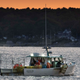 The crew on a lobster boat hauls traps off the coast of Portland, Maine.